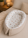 Nestchen Animals von AnTalin, weiches Nestchen mit Tiermustern zum Schutz und Komfort für Babys, auf einem weißen Hintergrund.
