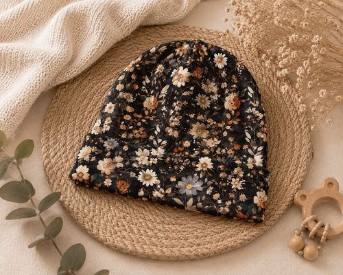 Handgefertigte Baby-Mütze "Midnight Meadow" von AnTalin mit floralem Design, aus weichem Material, ideal für kalte Tage.