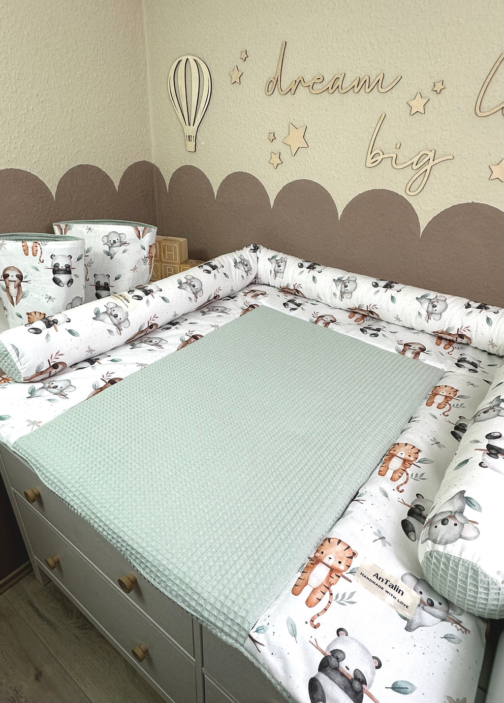 Wickelauflage Animals Friends von AnTalin, grüne Waffelpique mit bunten Tiermotiven, bequem und weich für Babys.