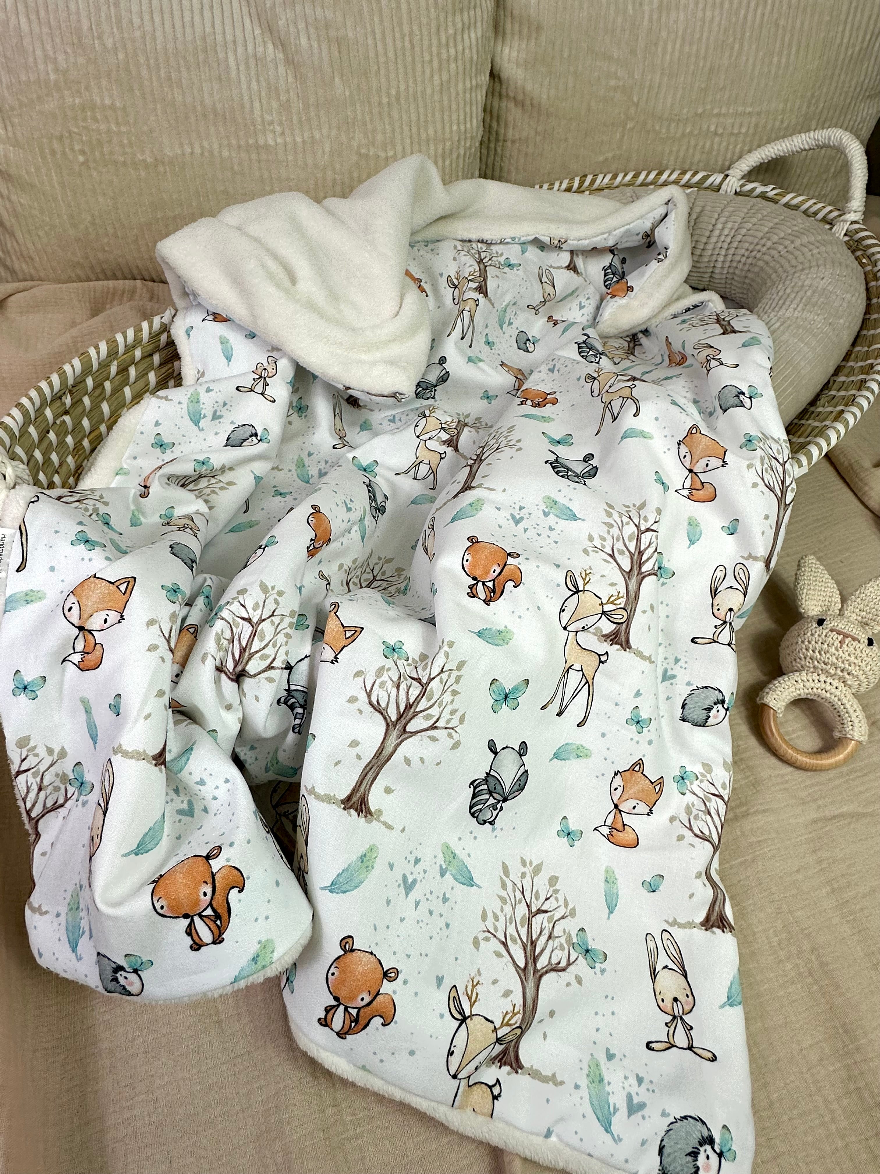 Weiche Babydecke von AnTalin, Kuscheldecke Waldfreunde aus Fleece, zeigt Baum- und Waldmotive in Naturfarben.