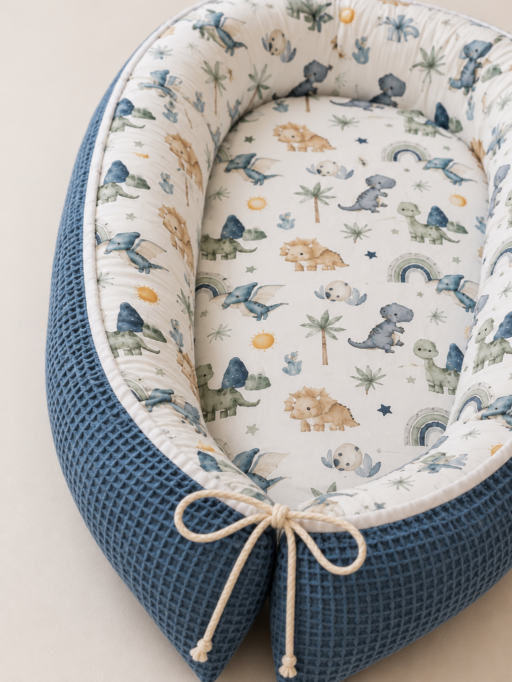 Nestchen kleiner Dino von AnTalin, weiches und sicheres Schutzpolster für Babys im Kinderbett, mit Dino-Design.