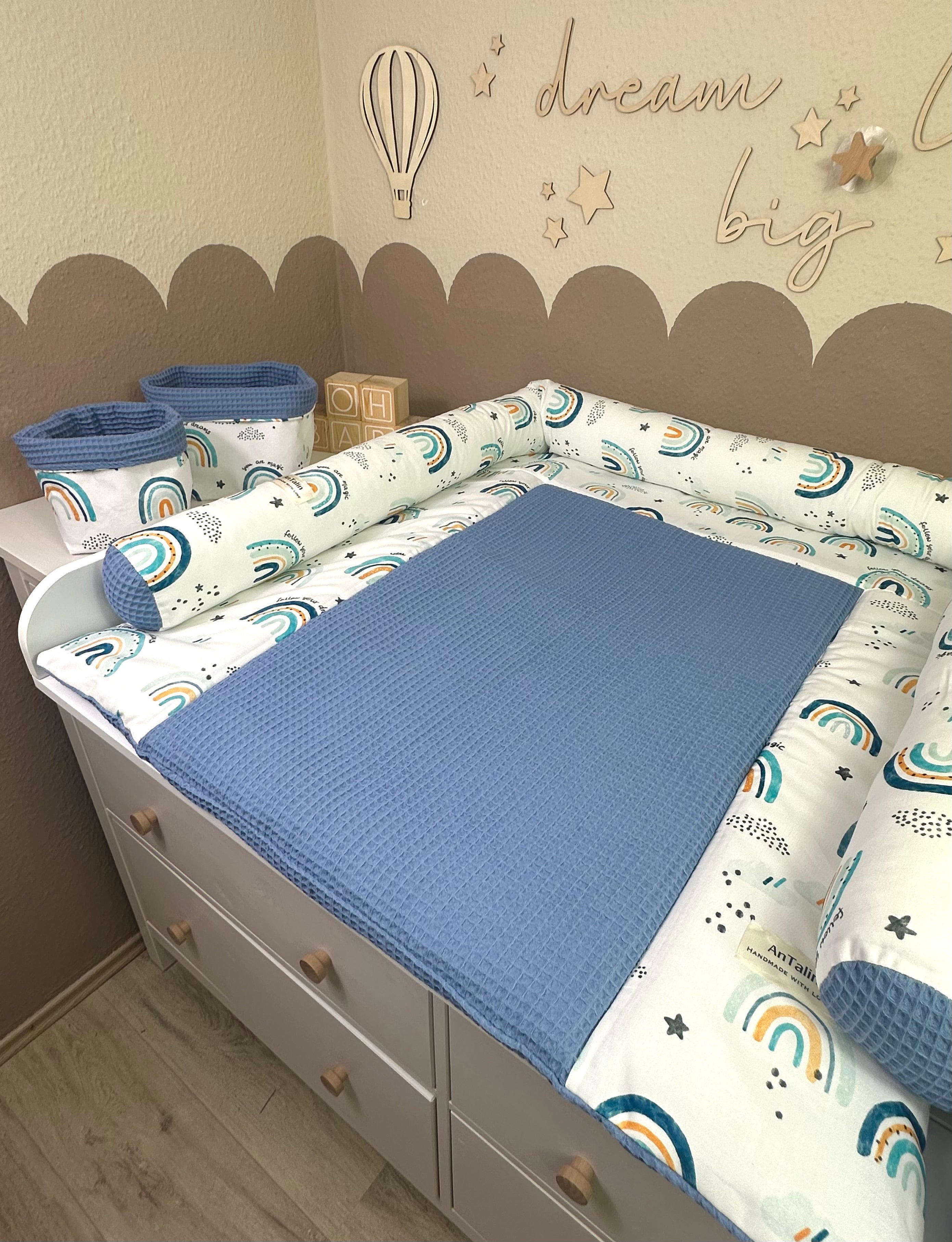 Blaue Wickelauflage Regenbogen von AnTalin mit buntem Regenmuster für Babys und Neugeborene.