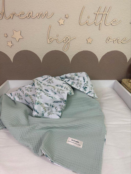 Weiche Babydecke von AnTalin mit Eukalyptuszweigen, kuscheliges Textil für Babys, zeigt das Muster und die angenehme Oberfläche
