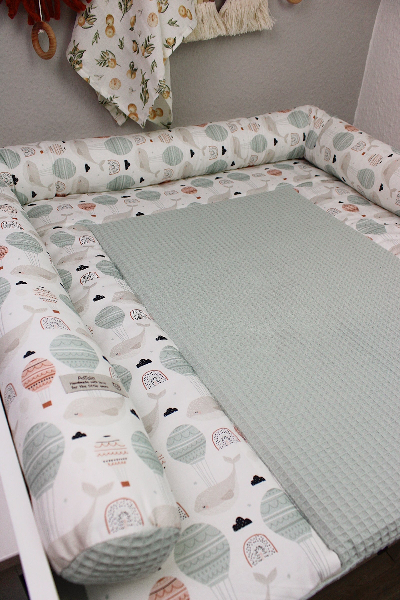 Weiche Wickelauflage mit kleinem Wal-Design von AnTalin, ideal für Babys. Bunte Stoffauflage mit Wal-Motiv.