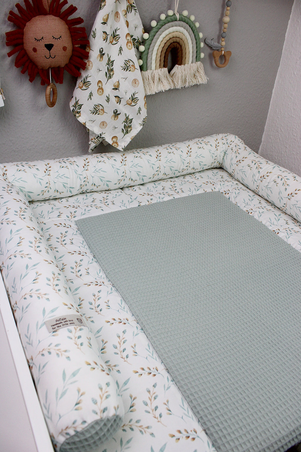 Weiche Wickelauflage im Frühlingsgarten-Design von AnTalin, mit bunten Blumen und grünem Hintergrund, perfekt für Babys.