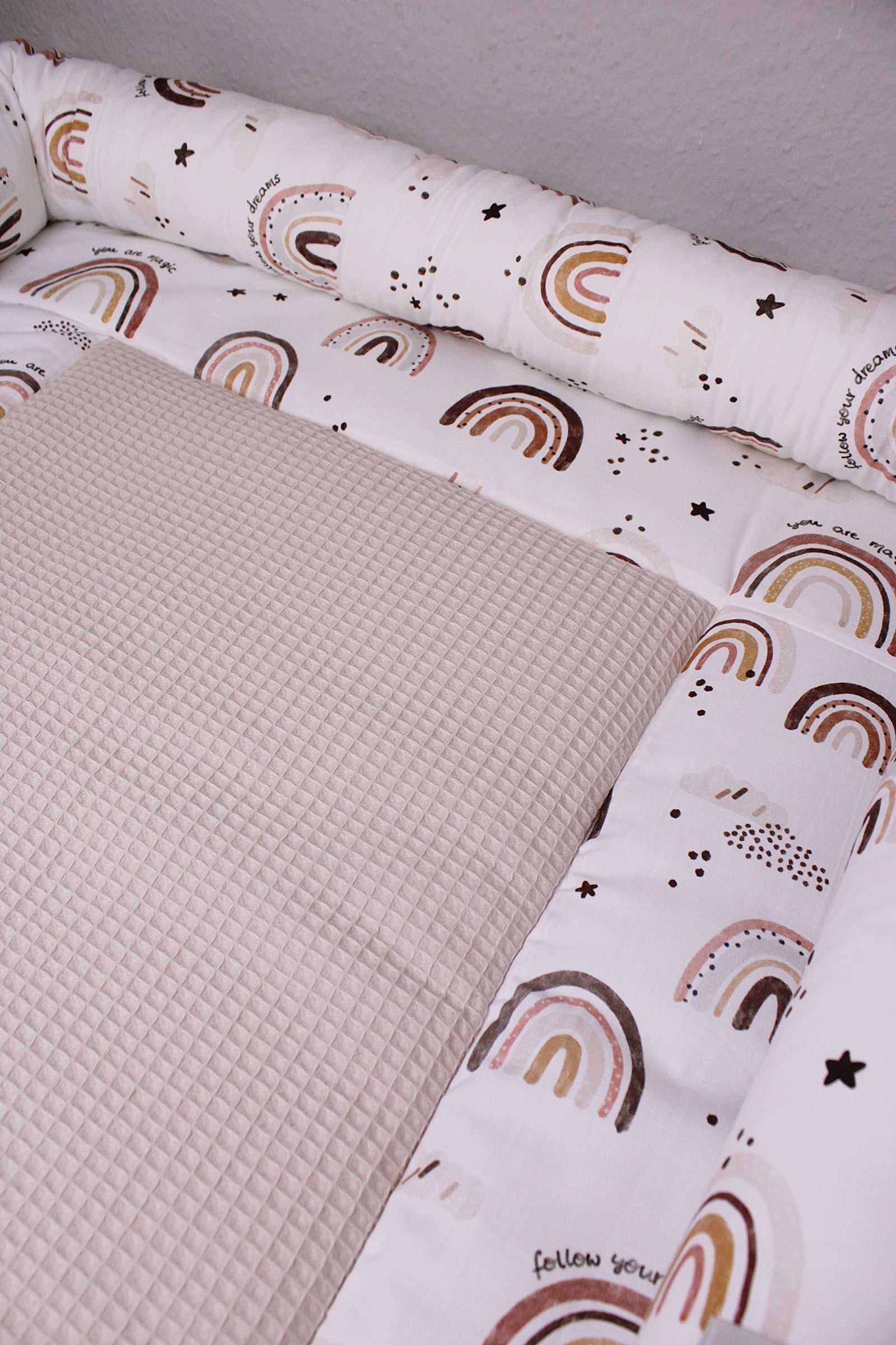Braune Wickelauflage mit Regenbogenmuster von AnTalin, weich und komfortabel für Babys, auf Wickeltisch gelegt.