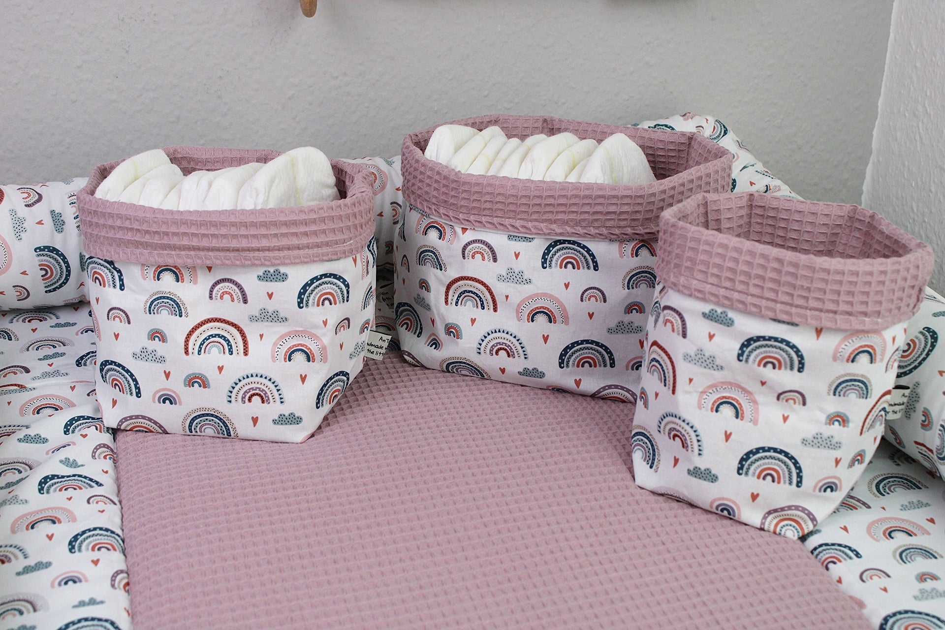 Pastellrotes Regenbogen-Utensilo von AnTalin, aus Stoff, mit bunten Regenbogenmotiven, ideal für Küchen- oder Kinderzimmer.